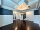 Open living room with hardwood floors, coffered ceiling and sleek light fixture at 2506 Monta Vista Way, Hoschton, GA 30548