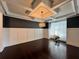 Spacious living room with hardwood floors, coffered ceiling and modern light fixture at 2506 Monta Vista Way, Hoschton, GA 30548