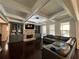 Cozy living room with coffered ceilings, built-in shelving, stone fireplace, and ample seating at 2506 Monta Vista Way, Hoschton, GA 30548
