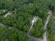 Aerial view of a house nestled amongst trees, with a long driveway and surrounded by green foliage at 2700 Sam Nelson Rd, Canton, GA 30114