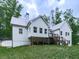 Back exterior view of a home with a deck and patio, nestled in a tranquil wooded setting at 2700 Sam Nelson Rd, Canton, GA 30114