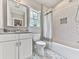Well-lit bathroom features decorative floor tiles, vanity, toilet, and shower with white subway tile at 2700 Sam Nelson Rd, Canton, GA 30114
