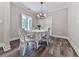 Elegant dining room featuring a chandelier, large windows, and comfortable seating for four at 2700 Sam Nelson Rd, Canton, GA 30114