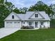 Charming home boasts a two-car garage, a metal roof, and rocking chairs on the front porch at 2700 Sam Nelson Rd, Canton, GA 30114