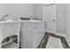 A well-equipped laundry room features a sink, modern washer and dryer, and stylish wood-look flooring at 2700 Sam Nelson Rd, Canton, GA 30114