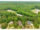 Aerial view of wooded neighborhood featuring ball fields, green lawns, and nearby homes at 374 Beaumont Farms Dr, Sharpsburg, GA 30277