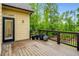 Wooden back deck with black railing looks out to green backyard and features an exterior door at 374 Beaumont Farms Dr, Sharpsburg, GA 30277