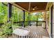 Back porch featuring white macrame hammock chair, dark wooden railing, and wooded backyard views at 374 Beaumont Farms Dr, Sharpsburg, GA 30277