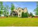 Expansive backyard with mature trees, lush landscaping, and a spacious covered deck, perfect for outdoor entertaining at 374 Beaumont Farms Dr, Sharpsburg, GA 30277
