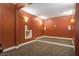 Basement room with a red wall, carpeted floor and a tiered platform at 374 Beaumont Farms Dr, Sharpsburg, GA 30277