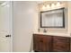 Bathroom with vanity, wood cabinets, white countertops and framed mirror at 374 Beaumont Farms Dr, Sharpsburg, GA 30277
