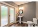 Bathroom with pedestal sink, toilet, decorative mirror and natural light from exterior door at 374 Beaumont Farms Dr, Sharpsburg, GA 30277