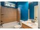 Cozy bathroom with tiled shower, blue walls, and a classic vanity with a sink at 374 Beaumont Farms Dr, Sharpsburg, GA 30277