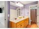 Bathroom with double sink, wood cabinets, large mirror and neutral countertops at 374 Beaumont Farms Dr, Sharpsburg, GA 30277