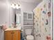 Small bathroom featuring cabinet, toilet and shower with playful curtain at 374 Beaumont Farms Dr, Sharpsburg, GA 30277