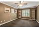 Bedroom with neutral walls, carpeted floor, bright window and built-in shelving at 374 Beaumont Farms Dr, Sharpsburg, GA 30277