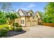 View of the home's exterior featuring a three-car garage and landscaped yard at 374 Beaumont Farms Dr, Sharpsburg, GA 30277