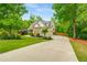 Charming two-story home with a long driveway, well-manicured lawn, and beautiful landscaping at 374 Beaumont Farms Dr, Sharpsburg, GA 30277