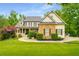 Charming two-story home with stone accents, manicured lawn and mature trees at 374 Beaumont Farms Dr, Sharpsburg, GA 30277