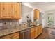 Open kitchen with granite countertops, stainless steel appliances, and hardwood floors leading to an outdoor area at 374 Beaumont Farms Dr, Sharpsburg, GA 30277