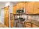 Well-equipped kitchen with wood cabinets, granite counters, stainless steel appliances, and unique sliding barn door at 374 Beaumont Farms Dr, Sharpsburg, GA 30277