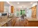 Spacious kitchen with granite countertops, stainless steel appliances, hardwood floors, and access to an outdoor dining area at 374 Beaumont Farms Dr, Sharpsburg, GA 30277