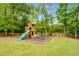 Backyard playground features a slide, swings, climbing tower, and seating area with fire pit at 374 Beaumont Farms Dr, Sharpsburg, GA 30277
