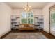 Sitting area with chandelier, large windows, and open area overlooking wooded yard at 374 Beaumont Farms Dr, Sharpsburg, GA 30277