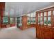 Bright sunroom featuring multiple windows, wood paneling and comfortable carpet flooring at 1082 Green Valley Nw Dr, Conyers, GA 30012