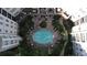 Aerial view of the community pool surrounded by lounge chairs, tables, and apartments at 11 Perimeter E Ctr # 1203, Dunwoody, GA 30346