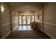 Community hallway with neutral walls and tile flooring leading to a door with glass panels at 11 Perimeter E Ctr # 1203, Dunwoody, GA 30346
