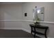 Carpeted hallway with dark wood table, floral arrangement, and decorative mirror at 11 Perimeter E Ctr # 1203, Dunwoody, GA 30346