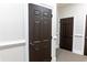 Hallway with dark wood doors and neutral colored walls and carpet at 11 Perimeter E Ctr # 1203, Dunwoody, GA 30346