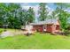 Charming brick home featuring a sprawling backyard, a basketball hoop, and beautiful green lawn at 201 Smithstone Path, Fayetteville, GA 30214