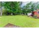 Large grassy backyard, with trees and garden, perfect for outdoor activities and relaxation at 201 Smithstone Path, Fayetteville, GA 30214