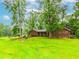 Traditional brick ranch-style home with green shutters nestled among mature trees, offering a serene setting at 201 Smithstone Path, Fayetteville, GA 30214