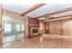 Cozy living room with brick fireplace, exposed wood beams, wood paneling, and sliding glass doors to patio at 201 Smithstone Path, Fayetteville, GA 30214