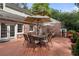 Charming brick home exterior with a spacious back deck and outdoor seating under umbrellas for relaxing and entertaining at 4105 Peachtree Dunwoody Ne Rd, Atlanta, GA 30342