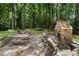 Inviting backyard patio with stone fireplace and outdoor seating, ideal for entertaining with the trampoline and lush green backdrop at 4105 Peachtree Dunwoody Ne Rd, Atlanta, GA 30342