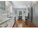 Well-lit kitchen with stainless steel appliances, white cabinets, granite countertops, and hardwood floors at 4105 Peachtree Dunwoody Ne Rd, Atlanta, GA 30342