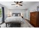 Spacious main bedroom with neutral color palette, ceiling fan, wood floors, and bench at the foot of the bed at 4105 Peachtree Dunwoody Ne Rd, Atlanta, GA 30342