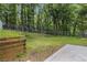 Large backyard with a chain link fence and retaining wall, surrounded by mature trees at 520 Cranberry Pl, Roswell, GA 30076