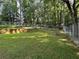 Green backyard featuring a chain-link fence, a small retaining wall, and mature trees at 520 Cranberry Pl, Roswell, GA 30076