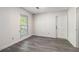 Bright bedroom with luxury vinyl plank flooring, one sunny window and a white door at 520 Cranberry Pl, Roswell, GA 30076