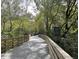 Scenic wooden bike trail with a bike path sign, shaded by trees on a sunny day at 520 Cranberry Pl, Roswell, GA 30076