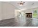 Spacious living room with wood flooring, stone fireplace, ceiling fan, and bright windows at 520 Cranberry Pl, Roswell, GA 30076