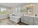 Luxurious bathroom featuring a soaking tub, double vanities, and elegant fixtures, providing a spa-like experience at 7120 Lullwater Rd, Cumming, GA 30040