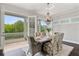 Bright dining room with a chandelier and beautiful views to the balcony and outdoors through french doors at 7120 Lullwater Rd, Cumming, GA 30040