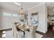 Formal dining room with wood floors, chandelier, and a view of the kitchen at 7120 Lullwater Rd, Cumming, GA 30040