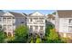 Charming three-story home with double balconies, lush landscaping, and a manicured lawn at 7120 Lullwater Rd, Cumming, GA 30040